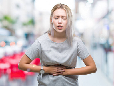 金发女人在孤立的背景下与手上的胃因为消化不良, 痛苦的疾病感到不适