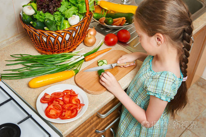 在家庭厨房做饭的儿童女孩篮子蔬菜和新鲜水果在厨房内健康食品概念