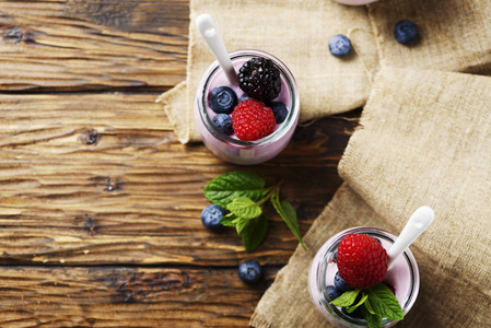 健康酸奶与浆果和薄荷在木桌上