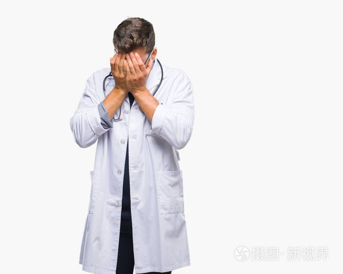 年轻英俊的医生在孤立的背景下, 带着悲伤的表情, 用手捂着脸哭泣.