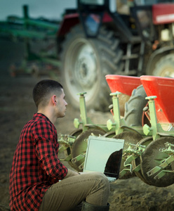 笔记本电脑和拖拉机的农民图片