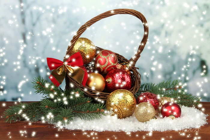 在篮子里在明亮的背景上的表有雪的圣诞装饰品