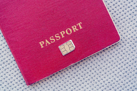 红色护照与 sim 卡在灰色的纺织品背景
