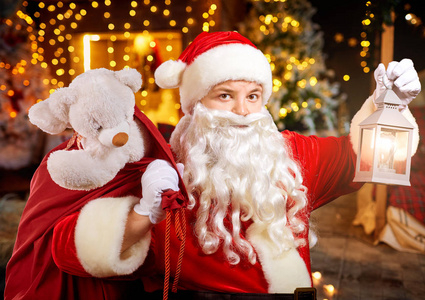 滑稽的圣诞老人与一个袋子在他的手在一个房间与壁炉