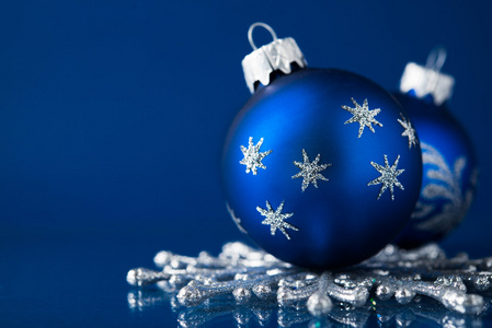 蓝色和银色圣诞饰品上深蓝色背景中，文本的空间。圣诞主题
