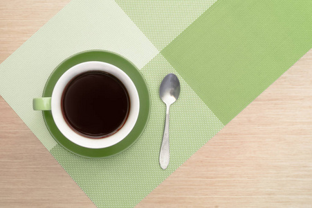 绿色杯咖啡桌上的背景和桌布和勺子