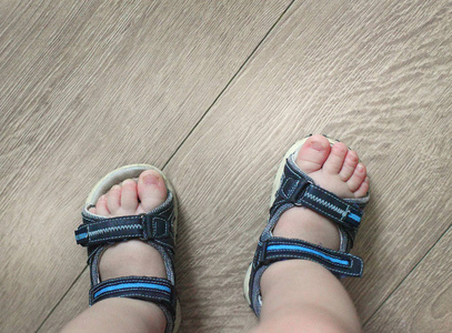 孩子们脚上的凉鞋.幼儿鞋.旅游凉鞋为最小的旅客.鞋店新购照片
