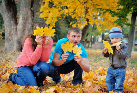 幸福美满的家庭放松在秋天公园图片