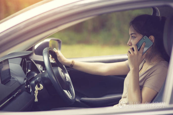 年轻女子开车时电话交谈的电话