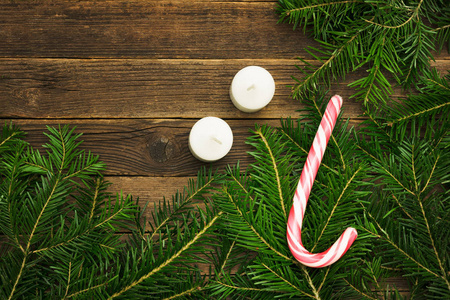木制背景。冷杉树枝, 糖果和蜡烛。圣诞节的概念