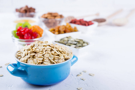 燕麦片在蓝碗和各种美味的成分, 健康早餐在厨房餐桌上。健康早餐概念