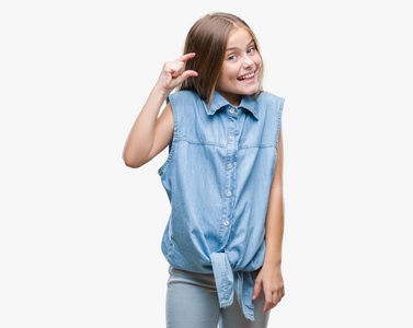 年轻美丽的女孩在孤立的背景下微笑和自信的手势与手做尺寸符号与手指, 当看和相机。度量概念