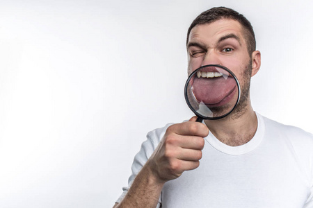 把舌头有放大镜的人正往前看, 用玻璃把舌头露出来.