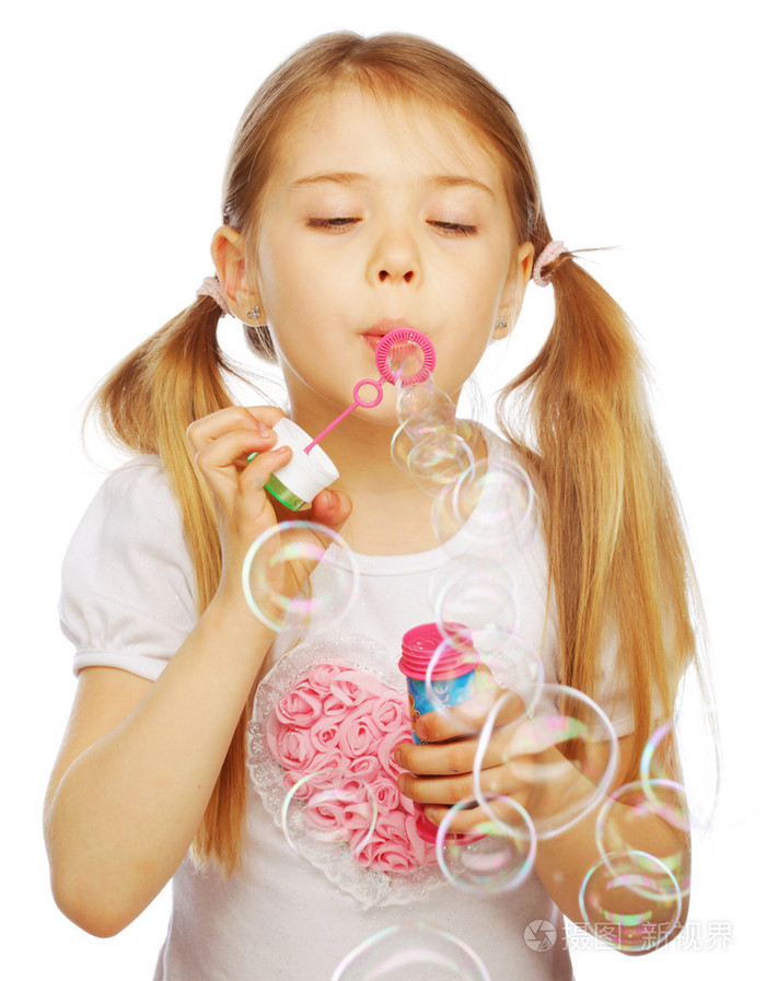 吹肥皂泡的滑稽可爱的小女孩