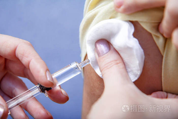 持有注射器的医生的手为预防流感疾病的患者上臂注射疫苗.