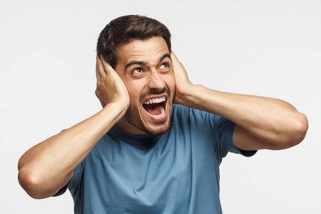 年轻人对吵闹的邻居大声喊叫,用双手捂住耳朵男人对他女朋友低声说了