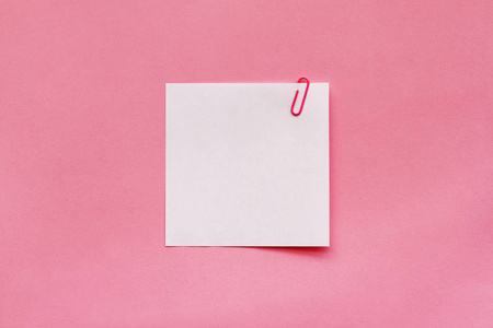 粉红色背景上带有剪辑的白色便笺纸标签