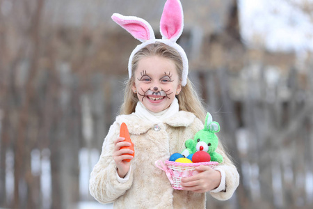 复活节假期有彩色鸡蛋和胡萝卜的小女孩肖像