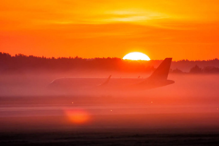 在雾和日出中滑行一架客机图片
