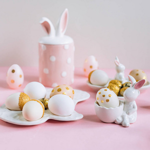 粉红色背景下的兔子形状的金色闪光复活节彩蛋
