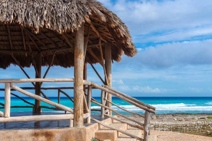 在加勒比海滩上有茅草屋顶的凉亭或平房