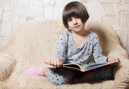 小小女孩微笑着读一本书