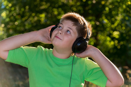 听音乐用耳机在公园里的男孩