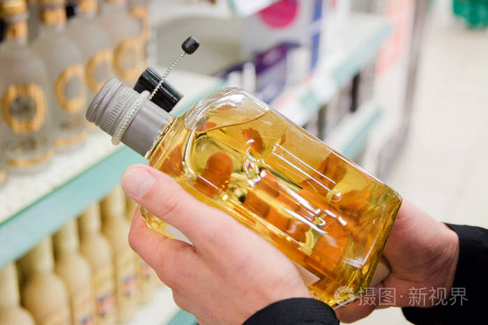 店里的男人手里拿着一瓶龙舌兰酒