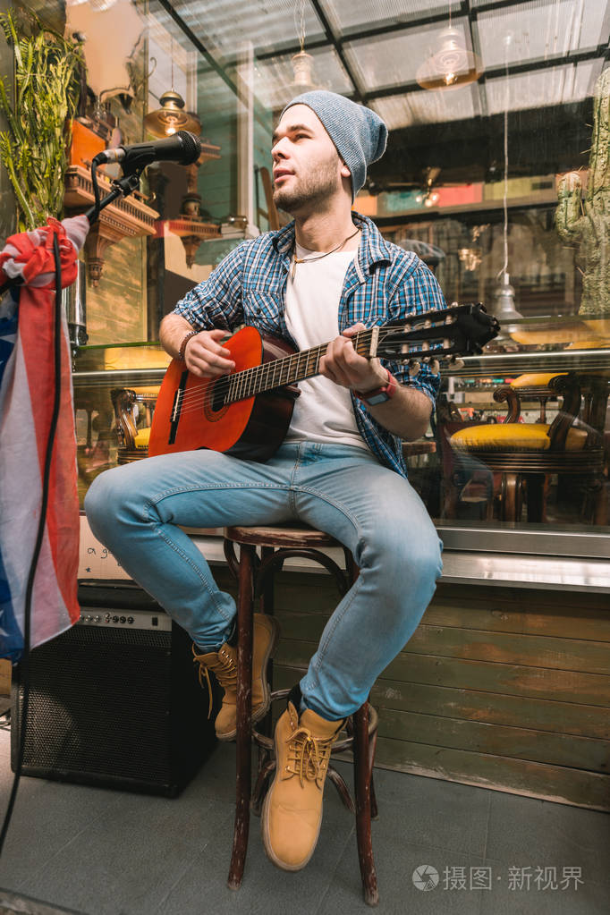 有重点的男性吉他手代表歌曲在酒吧