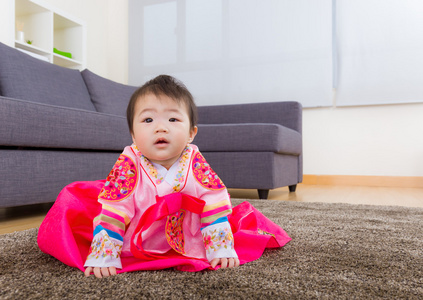 传统的韩国服装婴儿坐在地毯上图片