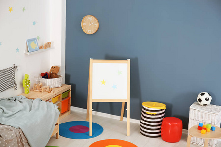 现代儿童房内有舒适的床和翻转图表板