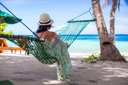 年轻女子躺在吊床上热带海滩
