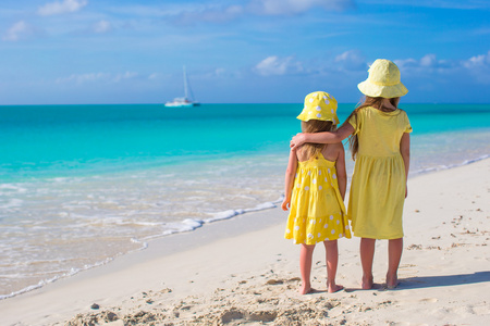 两个小女孩在热带海滩后面观