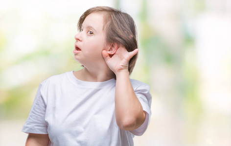 年轻的成年妇女与唐综合征在隔绝的背景微笑以手在耳朵听见谣言或八卦