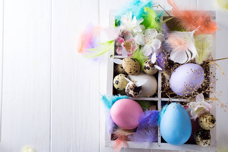 五颜六色的复活节彩蛋在木箱子在白色