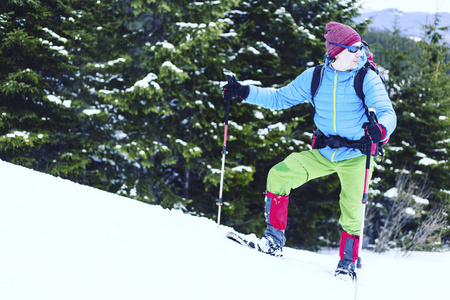滑雪鞋沃克在美丽的日出光粉雪中运行。冬季户外活动和健康的生活方式