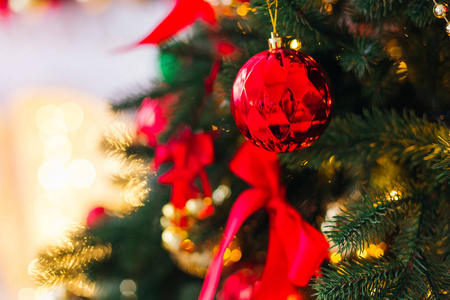 在圣诞树树枝上的一颗美丽的雕刻玻璃球的特写