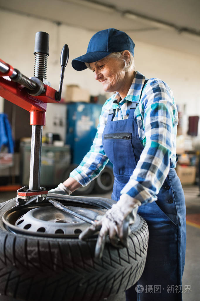 高级女技工在车库修车