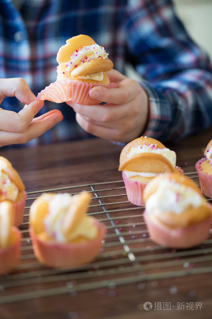 厨房里的女孩关门吃家做的杯子蛋糕