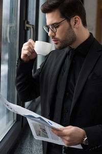喝咖啡和拿报纸的商人