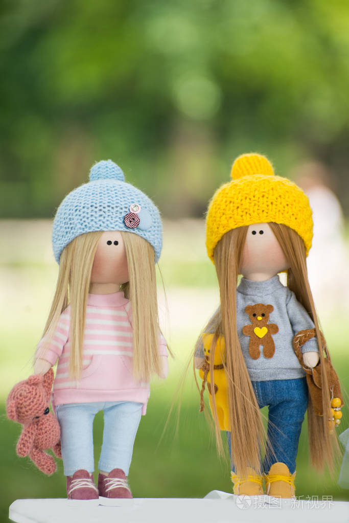 两个漂亮的手工娃娃在时髦的衣服