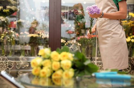 女性花店鲜花店里拿着美丽的花束