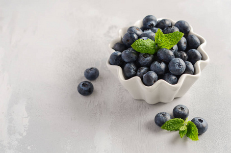 成熟的甜蓝莓在白色碗在灰色具体背景, 选择性焦点, 拷贝空间