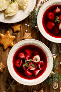 圣诞节甜菜根汤, 罗宋汤与小饺子, 蘑菇馅在一个陶瓷碗在木桌上, 顶部视图。在波兰的传统圣诞前夜菜