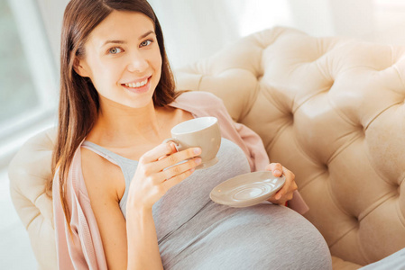 快乐可爱的女人躺着喝着一杯茶