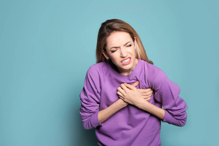 彩色背景心脏病发作的年轻女子照片