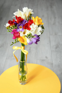 美丽的小苍兰花束在桌上花瓶