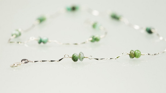 银色的耳环和项链与祖母绿宝石