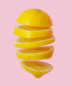 飞柠檬。切片柠檬被隔离在梯度粉红色背景。轻浮水果