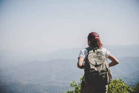 有魅力的女子徒步旅行在山顶, 享受大自然。旅游理念